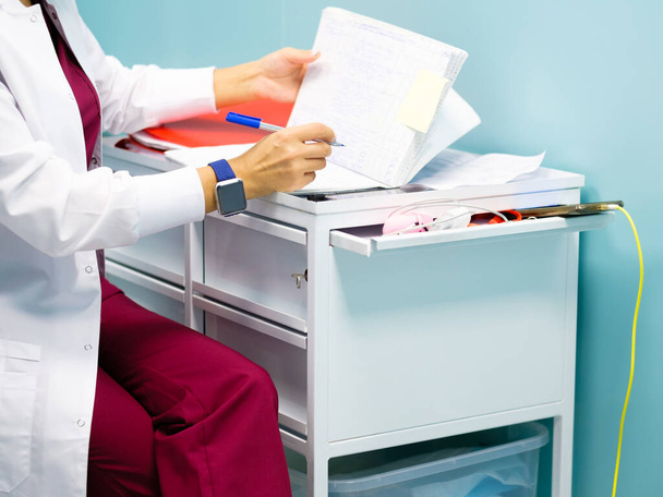 Female doctors hands fill out medical documents - Foto, Imagen
