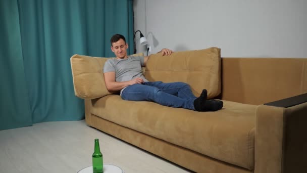 Staubsaugerroboter liefert Alkohol an Mann auf Sofa - Filmmaterial, Video