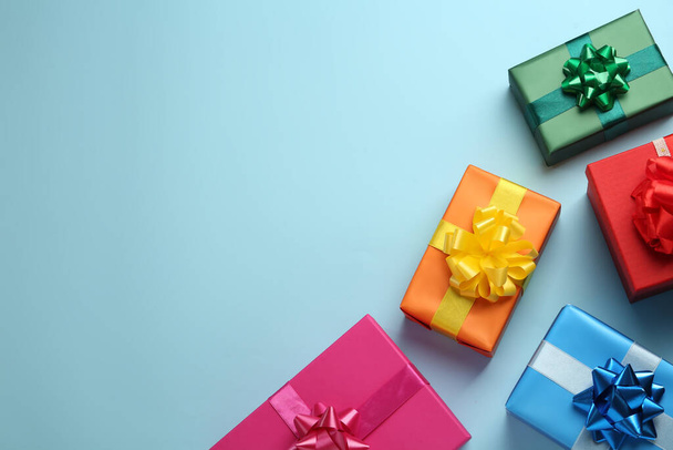 Many colorful gift boxes on light blue background, flat lay. Space for text - Фото, зображення