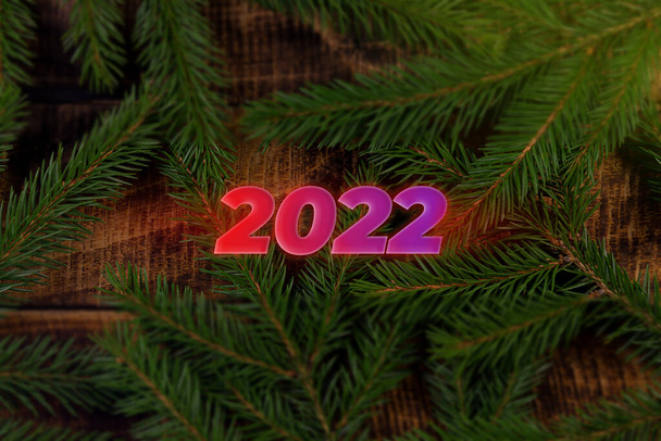 inscription Merry Christmas 2022 spruce on a wooden background holiday card. - Foto, immagini