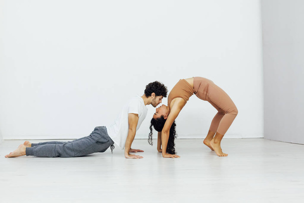 a woman and a man engaged in paired gymnastics yoga asana - Foto, Imagem
