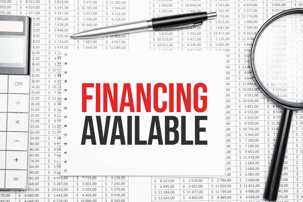 FINANCING AVAILABLE text on paper with calculator,magnifier ,pen on the graph background - Fotó, kép