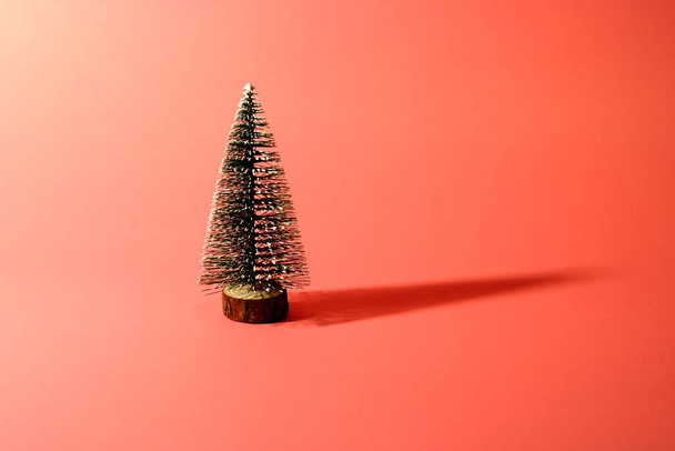 Minimal composition pattern background of green Christmas tree on pastel red. New year concept. - Valokuva, kuva
