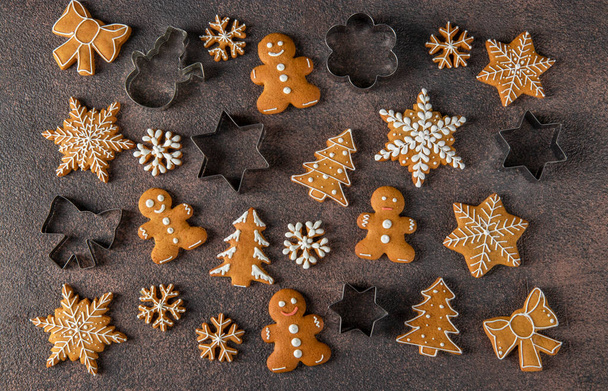 Homemade christmas gingerbread cookies and cookie cutters on brown background, Flat lay, Top view - Fotografie, Obrázek