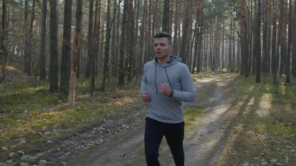Silny biały mężczyzna biegnie w lesie - Materiał filmowy, wideo