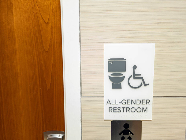 Halka açık bir tuvaletin girişindeki tüm cinsiyet tuvaleti işaretlerini gösteren izole edilmiş görüntüleri kapat. Bu tesisler ülke çapında daha yaygın ve popüler hale geliyor.. - Fotoğraf, Görsel