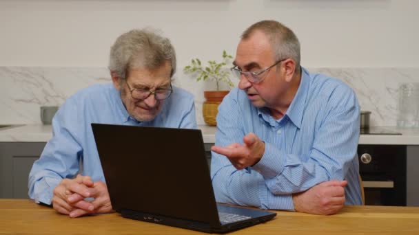 Ältere ältere Männer benutzen einen Laptop, während sie sich zu Hause entspannen - Filmmaterial, Video