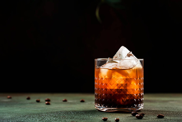 Black russian cocktail, trendy alcoholic drink with vodka, coffee liqueur and ice, rusty green dark background - Foto, Bild