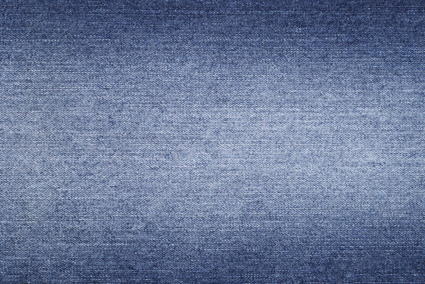 Fondo de mezclilla en tela azul con desvanecido. Pantalones vaqueros azules descoloridos de cerca  - Foto, imagen