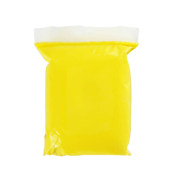 Package of yellow play dough on white background, top view - Fotó, kép