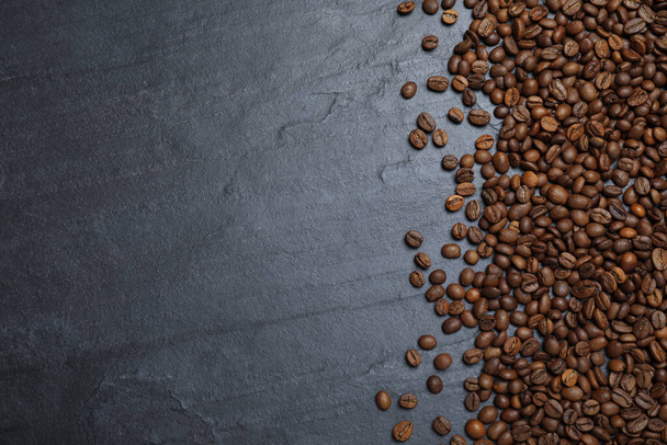 Many roasted coffee beans on black table, flat lay. Space for text - Foto, immagini