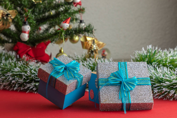 regali con fiocco blu, con un albero di Natale sullo sfondo - Foto, immagini