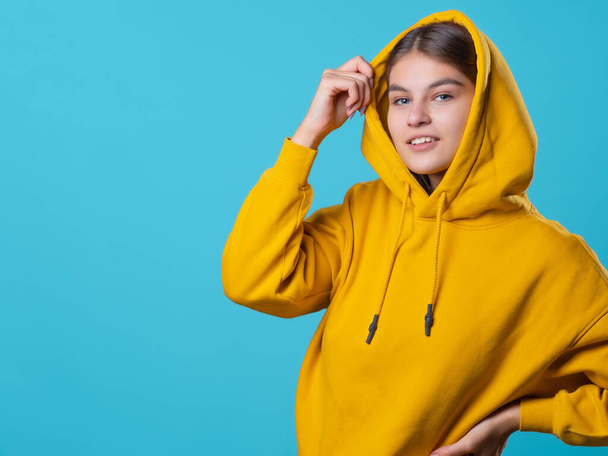 Beautiful young brunette with a hood on her head, youth oversize clothing style, - Foto, afbeelding