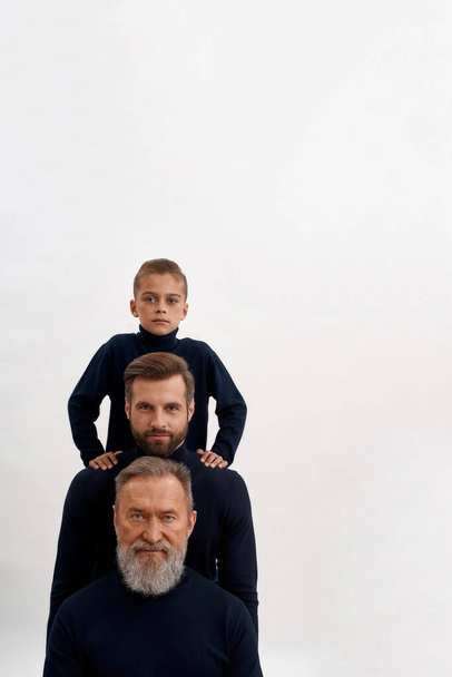 Three generations of men stand in row - Foto, Imagem