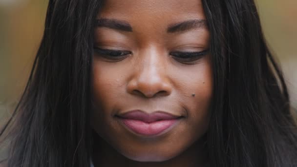 Nahaufnahme schöne freudige afrikanisch-amerikanische Mädchen Blick auf Kameraporträt junge Frau breit lächelnd mit gesunden weißen Zähnen im Freien glücklich multirassische weibliche schwarze Haut und lange Haare posieren außerhalb - Filmmaterial, Video