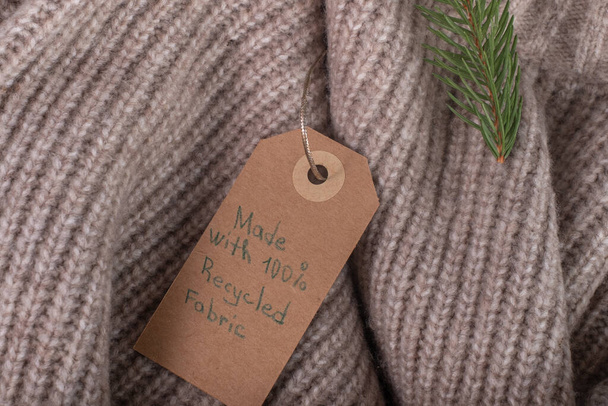 Label made with recycled fabric and decorated with a Christmas tree branch. Ecological and sustainable fashion. High quality photo - Photo, Image