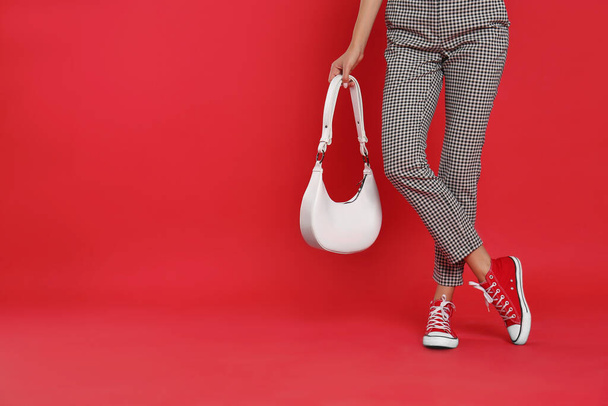 Woman with stylish bag on red background, closeup. Space for text - Photo, Image