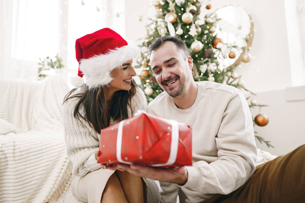 Young cheerful couple in love with present for Christmas - Foto, afbeelding