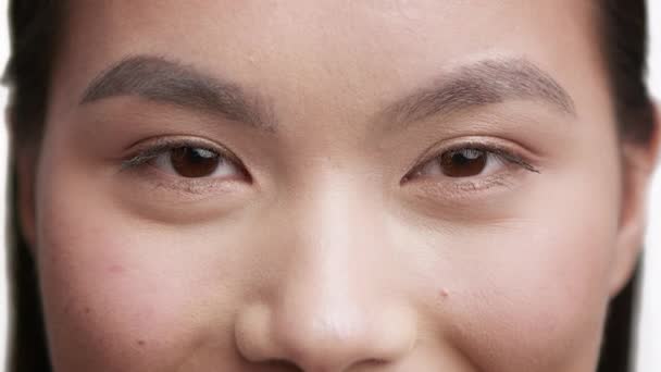 Fechar-se de jovem asiático feminino olhando para a câmera, fundo branco - Filmagem, Vídeo