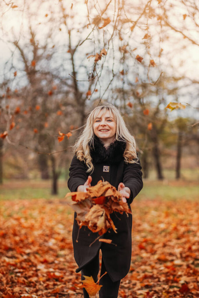 Chica muy feliz y olorosa está en el parque de otoño, divirtiéndose  - Foto, Imagen
