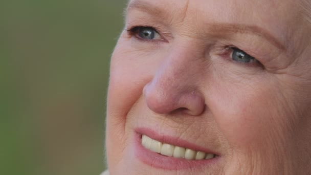 Snímek hlavy detailní portrét příjemné usměvavé dospělé ženy. Šťastná zdravá dáma středního věku, odpočívající sama, dívající se stranou, se širokým úsměvem, rovné bílé zuby. Pozitivní spokojený koncept odchodu do důchodu - Záběry, video