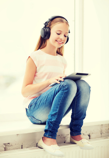 girl with tablet pc and headphones at home - Foto, immagini