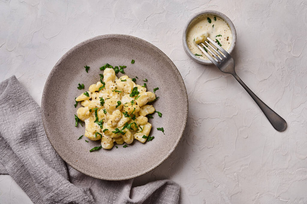 Top view Alpine dish gnocchi, prepared with potato and whole grain flour dough with cream sauce - 写真・画像