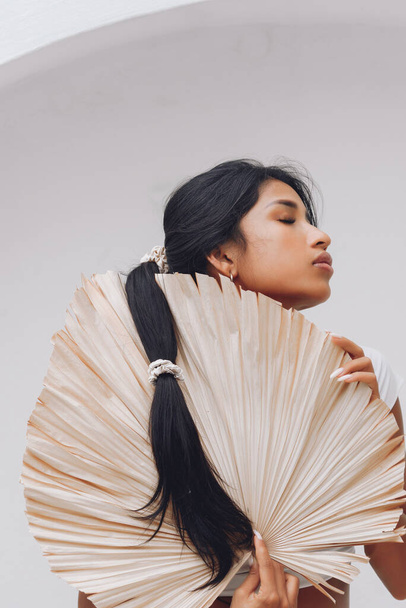 Asian girl with beautiful hair demonstrates silk scrunchies on white backgroun - Fotó, kép