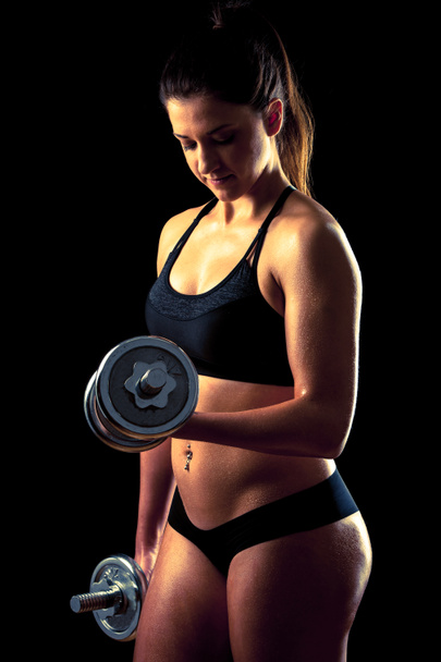 Fitness meisje - aantrekkelijke jonge vrouw uit te werken met halters - Foto, afbeelding