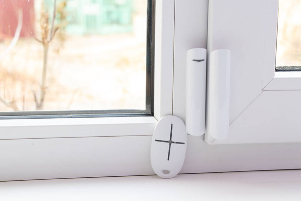 otthoni biztonsági rendszer az ablakokon, nyitás érzékelő és távirányító nyitás és zárás, távirányító a ház riasztás - Fotó, kép