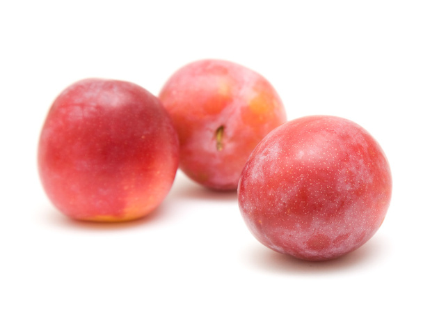 Light red ripe large plums, three fruits, isolated on white background - Фото, изображение