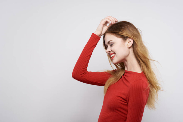 όμορφη γυναίκα μόδα χτένισμα κόκκινο πουλόβερ μοντέλο φως φόντο - Φωτογραφία, εικόνα