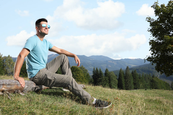 Man enjoying beautiful mountain landscape on sunny day - Valokuva, kuva