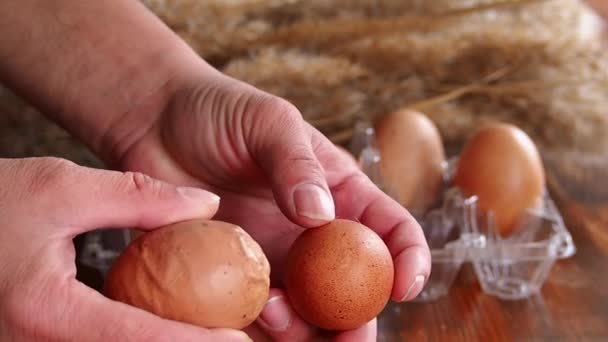 Vista de cerca de un huevo de gallina deformado. Un feo huevo torcido anormal comparado con el correcto. Falta de oligoelementos en el cuerpo de pollos viejos - Imágenes, Vídeo