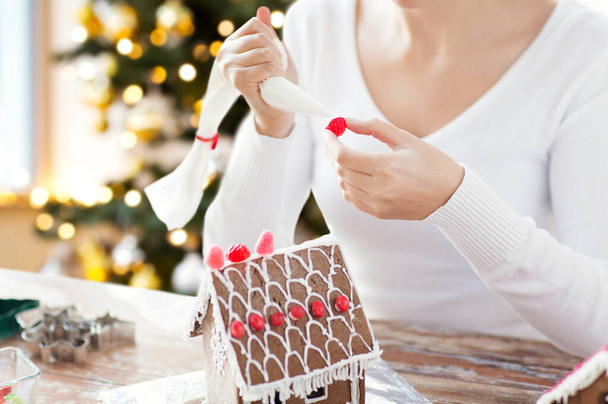 close up of woman making gingerbread house - 写真・画像