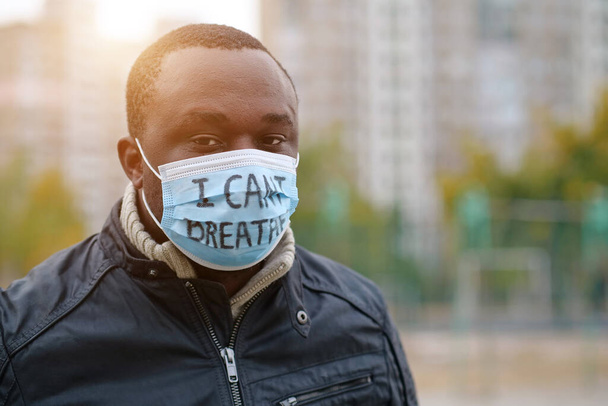 Afrikkalainen amerikkalainen mies aktivisti lääketieteellisessä naamiossa, jossa on kaiverrus, jota en voi katsoa kameraan. Black Lives Matter, BLM, rotusyrjintä, massamielenosoitukset Yhdysvalloissa - Valokuva, kuva