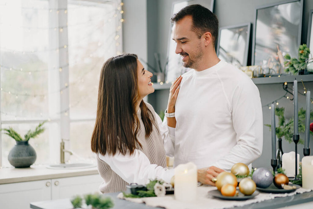 Young loving couple having good time at Christmas morning in kitchen - Foto, Imagen