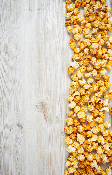 caramelized popcorn on wooden surface - Photo, image