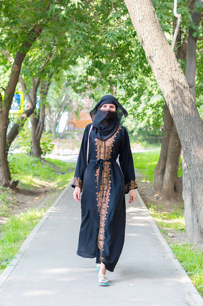 Arab woman national dress walks along a European city. - Fotoğraf, Görsel