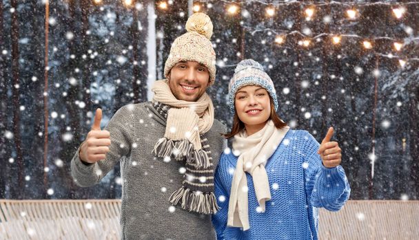 happy couple in winter clothes showing thumbs up - Foto, Imagem