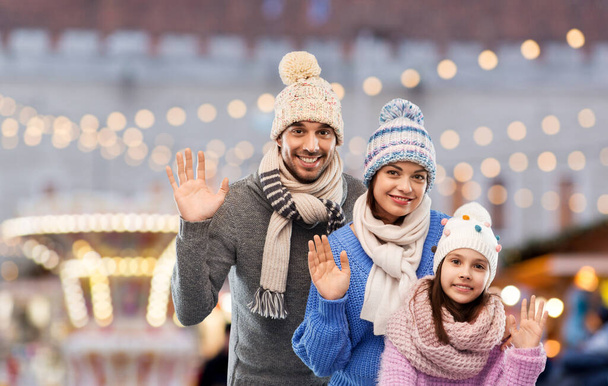 happy family in winter clothes waving hands - Photo, image
