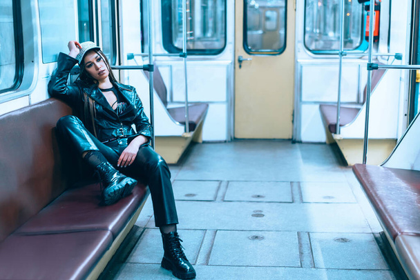 Sad Caucasian Young Woman Returns from a Late Night Party on the Last Subway Train AT Midnight. Sexy Female Sitting Relaxed on The Seat in an Empty Subway Car. Close-up  - Φωτογραφία, εικόνα