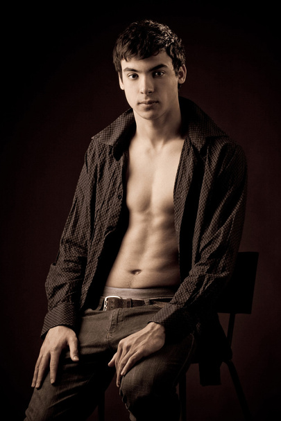 Portrait of a young man with unbuttoned shirt - 写真・画像