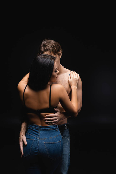 sexy mladý pár objímající se navzájem, zatímco stojí na černé  - Fotografie, Obrázek