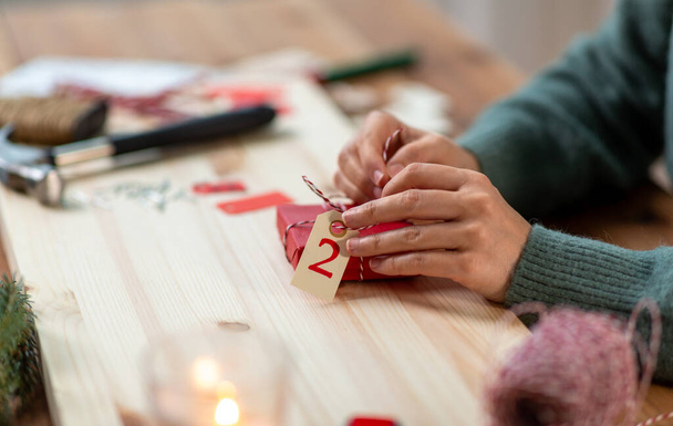 hands packing christmas gift for second advent day - 写真・画像