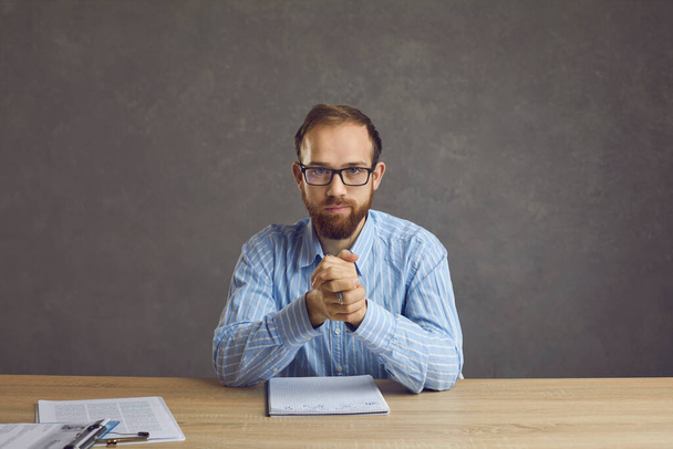 Serious confident job candidate or HR manager sitting at desk during job interview - Photo, Image