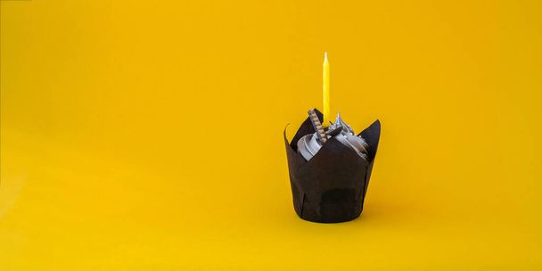 Herkullinen suklaakakku kermalla ja kynttilällä tummalla taustalla. Suklaamuffini. Syntymäpäiväkakkujuhlat. Kotitekoinen leipomo - Valokuva, kuva