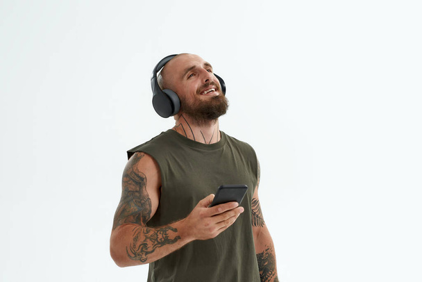 Joyful man listen music in earphones on smartphone - Photo, image