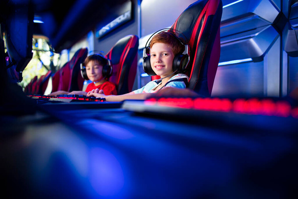 Retrato de joven jugador profesional con auriculares jugando videojuegos de ordenador y disfrutando de la industria del entretenimiento. - Foto, Imagen