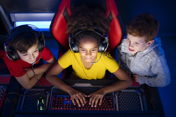 Top view of children playing video games together on the computer. - Zdjęcie, obraz